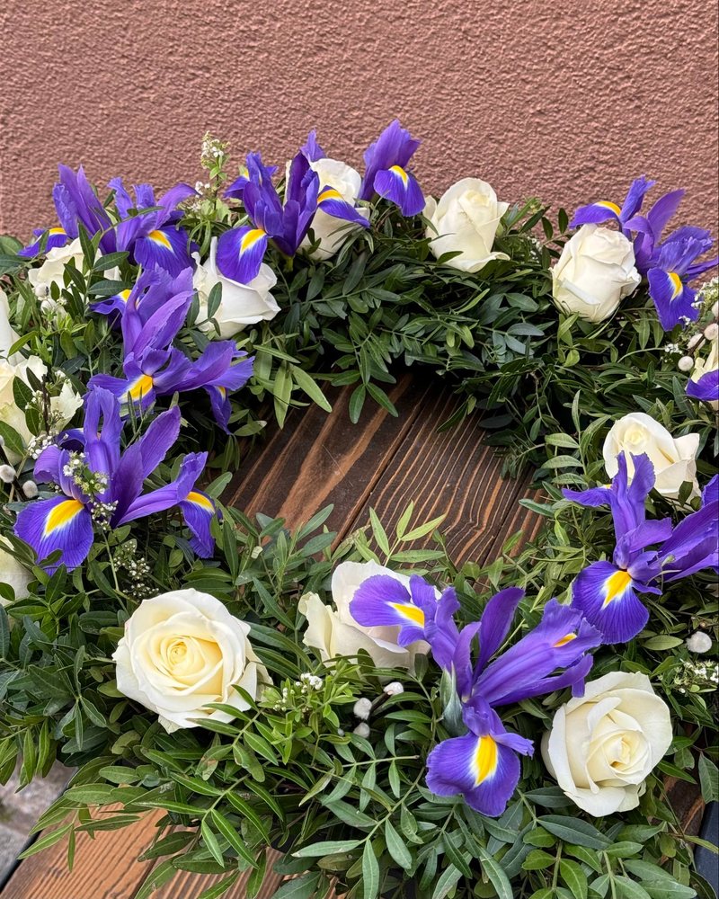 Kranz aus blauen Iris, weißen Rosen und Grün